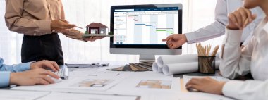 İç mimar tasarımcı grubu, daha kesin tasarım için planlar ve dizüstü bilgisayar ekran mimari yazılımı üzerinde birlikte tartışıyorlar. Modern ev tasarımı ve yenileme. İçgörü