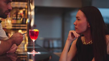 Barmen lüks tezgah barında güzel misafirler için çiçeklerle süslenmiş karışık votka kokteyli servis ediyor. Mükemmel canlı renk sunumu. Atmosfer gece kulübünü ön plana çıkarıyor. Vinosity.