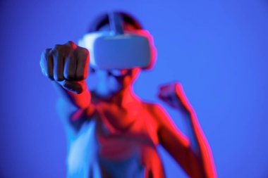 VR kulaklık takan zeki bir kadın metaevrene bağlanıyor, gelecekteki siber uzay topluluğu teknolojisi. Duruş kontrol oyuncusunu yumruklayan zarif bir kadın dövüş oyunları oynuyor. Halüsinasyon.