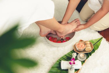 Adam lüks kaplıcalarda mutlu ayak masajına devam ederken, masör de hafif gün ışığı atmosferinde refleksoloji terapisi ya da otel ayak spa 'sında. Sessiz.