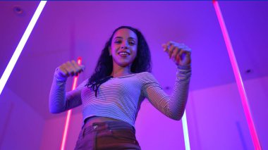 Latin dansçıların kameraya bakıp şehrin pop müziğiyle dans ettiği düşük açılı kamera. Profesyonel çekici hipster, mor veya neon ışıklı hip hop şarkısına geçiyor. Şık bir kumaş. Mutluluk.