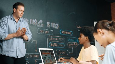 Afrikalı akademik öğrenci robot tamir ederken ya da araba modeli yapısını öğrenirken zeki beyaz kız programlama sistemi. Mühendislik eğitimi alan yetenekli, mutlu bir genç. Yaratıcı eğitim. Öğretim.