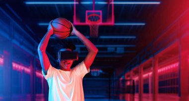 Basketbolcu fütüristik spor sahasında basketbol hologramı çekiyor. Artırılmış gerçeklik teknolojisi kullanarak basketbol becerisi geliştiren enerjik sporcu ya da sporcu. Yenilik. Yaratıcılık.