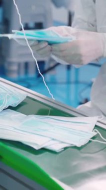 Modern fabrikada yüz maskesi üretim hattı. Covid-19 Coronavirus 2019 üretimi kavramı .