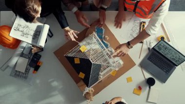 Akıllı mimar mühendis ekibinin yukarıdan görünüşü ev modelini incelerken müdürün elinde bina inşaatı hakkında sorular var. Çeşitli mühendislerden oluşan bir grup birlikte çalışıyor. Hizalama.