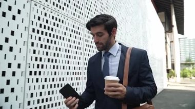 İş adamı telefona cevap verir ve iş yatırımları hakkında konuşur. İş planı, pazarlama stratejisi ya da çalışma hakkında konuşmak için akıllı telefonla konuşurken sokakta yürüyen mutlu bir yönetici. Sevinçli..