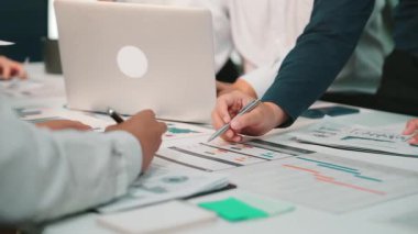 Çeşitli profesyonellerden oluşan bir grup modern bir ofiste ortak bir toplantıya katılıyor. Başarı ve yenilik stratejilerini tartışırken finansal verileri analiz ediyorlar. SACTR