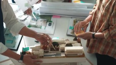 Akıllı mimar ya da inşaat mühendisi bina yapısı fikrini not edip plana yapıştırıyor. Yöneticinin çeşitli meslektaşları ve ev planlarıyla birlikte çalıştığı hava görüşü. Hizalama.