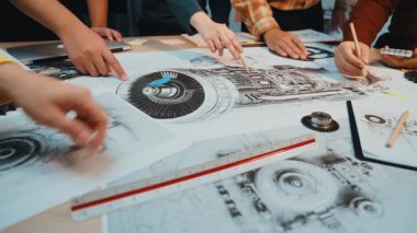 Çeşitli mühendisler bir çalışma masasındaki ortak çabalara odaklandılar, teknik çizimler ve tasarımları keşfederken beyin fırtınası ve tartışmalara giriştiler. SACTR