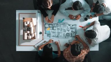 Proje yöneticisi ya da inşaat mühendisinin planlama ve planlama binasında yazışmalarının üst düzey görüntüsü. Toplantı masasında birlikte çalışan mimarın belgeyle birlikte havadan görünüşü. Hizalama.