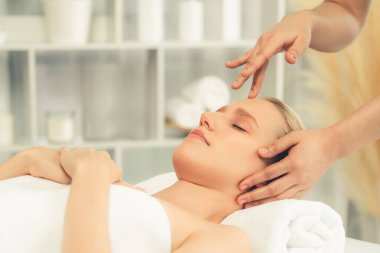 Kafkasyalı kadın stres önleyici kafa masajından ve lüks tatil beldesi ya da otel spa salonundaki modern ışık ortamında yüz güzelliği eğlencelerini şımartmaktan hoşlanıyor. Sessiz.