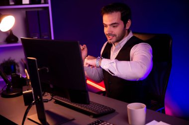 Gülümseyen zeki işadamı, elinde kahve fincanı olan satış ekibiyle buluşuyor ve geceleri Mor Neon Light Home Office 'deki bilgisayar ekranında ürün hedef pazarını araştırıyor. Tahmin et..