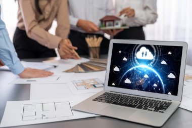 İç mimar tasarımcı grubu, daha kesin tasarım için planlar ve dizüstü bilgisayar ekran mimari yazılımı üzerinde birlikte tartışıyorlar. Modern ev tasarımı ve yenileme. İçgörü