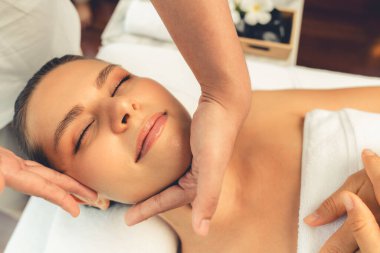 Kafkasyalı kadın stres önleyici kafa masajından ve lüks tatil beldesi ya da otel spa salonundaki modern ışık ortamında yüz güzelliği eğlencelerini şımartmaktan hoşlanıyor. Sessiz.