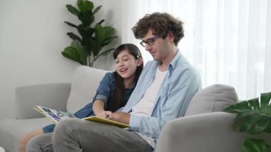 Beyaz bir baba ve tatlı bir kız kanepede otururken masal kitabı okuyorlar. Mutlu bir baba, sevimli bir Amerikan çocuğuna, birlikte zaman geçirirken hayal gücünün gelişmesi için hikaye anlatıyor. Pedagoji.