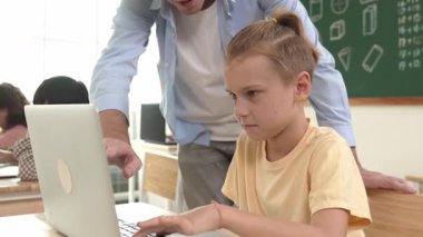Çeşitli öğrenciler yapay zeka yazılımı kullanırken, Kafkas öğretmeni enerjik çocuğa kodlama konusunda yardım ediyor. Çocuklar oturma ve programlama sistemi. Sevimli bir öğrenci şifreyi öğreniyor. Pedagoji.