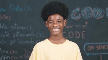 Makineye gülümseyen Afrikalı bir yetişkin. Mühendislik koduyla ya da dakik bir şekilde tahtada dururken. BTMM Teknoloji dersine katılırken günlük kıyafet giyen yakışıklı bir genç. Öğretim