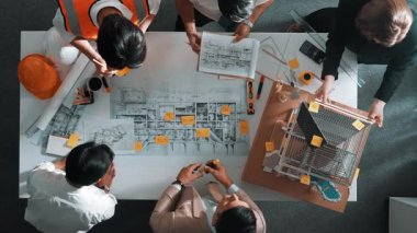 Becerikli mühendis ekibinin ev inşaatından bahsedişinin en alt görüntüsü. Mimar ya da tasarımcı grubunun planlar hakkında beyin fırtınası yapmak için tartışan ve yazan hava görüşü. Hizalama.