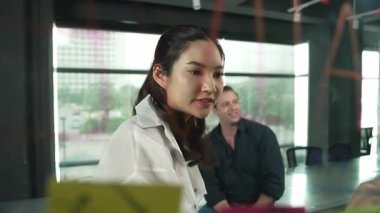 Genç kendine güvenen iş kadını projeyi uzman yatırımcıya sundu. Profesyonel proje yöneticisi başlangıç projesini açıklamak için yapışkan notlar kullanır, beyin fırtınası fikirlerini yatırımcıya paylaşır. Yönlendirici.