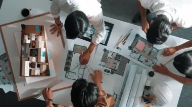 Akıllı mimar mühendisinin planlarını mimari ekipmanlar kullanarak ölçerken tasarımcılar toplantı odasında bina tasarımı ya da ev inşaatı hakkında konuşuyorlar. Hizalama.