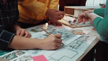 Mimarlar ve tasarımcılardan oluşan çeşitli bir ekip, planlar ve planlarla dolu, organize bir çalışma alanı üzerine fikirleri tartışarak ve çizerek yenilikçi kavramlar üzerinde birlikte çalışırlar. SACTR