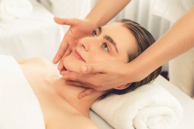 Kafkasyalı kadın stres önleyici kafa masajından ve lüks tatil beldesi ya da otel spa salonundaki modern ışık ortamında yüz güzelliği eğlencelerini şımartmaktan hoşlanıyor. Sessiz.