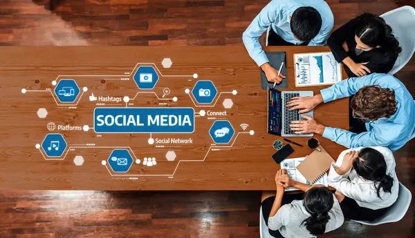 Çeşitli bir ekip, dizüstü bilgisayarlar ve dijital platformlardaki bilgi grafikleri ve veri analizleri yoluyla sosyal medya stratejilerini analiz ederek çağdaş bir ofis ortamında işbirliği yapıyor. Dostluk