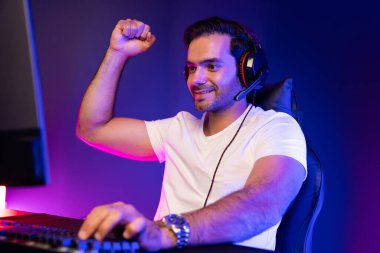 Çevrimiçi oyun oynayan, kulaklık takan, sosyal medyayla oyun oynayan oyuncuya yumruk kaldıran biri. Esport beceri takımı oyuncusu çevrimiçi dijital oyun stüdyosunda. Tahmin et..