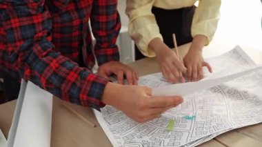 Mimari ekipmanlarla toplantı masasında ev tasarımı üzerine profesyonel mühendis ekibi tartışması ve modern ofiste bina planı dağılımı. Eline odaklan. - Yakın çekim. Tanımlama.