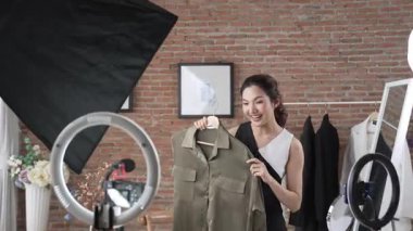 Kadın nüfuzlu kişi video görüntülerini canlı yayınlıyor. Sosyal medya ya da blog. Stüdyo ışıklandırması olan mutlu genç bir kız pazarlama için internet üzerinden yayın yapıyor..