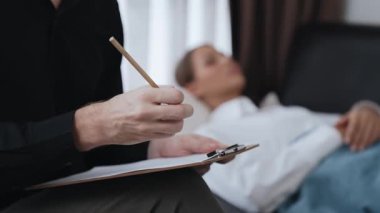 Çömelmiş yatmakta olan genç bir kadın hasta ofiste zihinsel tedavi sırasında travmatik bir olay, endişe ve akıl hastalığından psikiyatriste duygu salıyor. Psikolojik danışma seansı. Düzenle