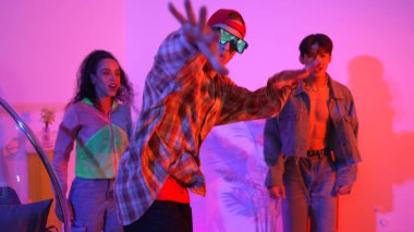 İspanyol hipster renkli kıyafetler giyer ve serbest stil müziğe el sallar. Profesyonel break dansçı neon ışıklarıyla ve modern stüdyo arkadaşlarıyla coşkuyla dans ediyor. Mutluluk.