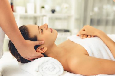 Kafkasyalı kadın stres önleyici kafa masajından ve lüks tatil beldesi ya da otel spa salonundaki modern ışık ortamında yüz güzelliği eğlencelerini şımartmaktan hoşlanıyor. Sessiz.