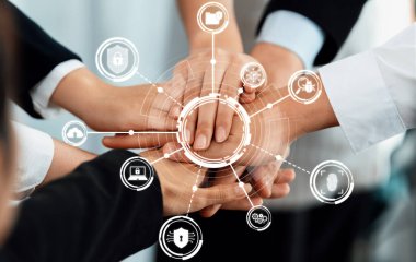 Çeşitli ellerin bir araya geldiği, koruma ve güvenlik kavramlarını temsil eden dijital ikonlar tarafından çevrelenmiş takım çalışmalarını ve güvenlik stratejilerini sembolize eden ortak bir sahne. Dostluk