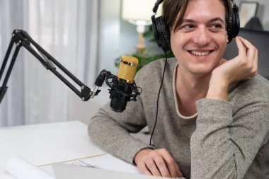 Sunucu kanalı, gülümseyen akıllı yayıncı kaydı, senaryosu ve akıllı telefonuyla sosyal medyada sohbet programı, kulaklık takarak modern ev stüdyosundaki video flamalarını kaydediyor. Bireysel.