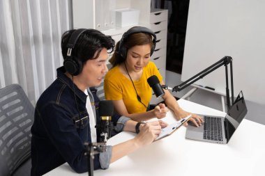 Gülümseyen radyo etkili sunucular, kulaklık takarak sosyal medya kanalından canlı yayın yapıyorlar ve sabah saatlerinde stüdyo kaydında dinleyicilere konu ve dizüstü bilgisayar üzerinden konuşuyorlar. İnfobahn.