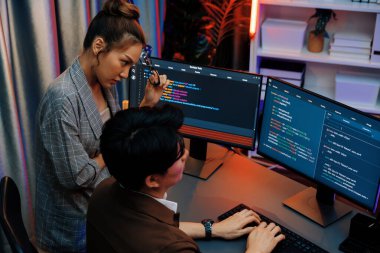 Bilgi teknolojisi modern ofisteki neon ışık odasında iki ekranın bilgisayarında veri çalıştıran akıllı web sitesi geliştirme kodlayıcı sistemi ile tartışan bilişim geliştiricileri. İnfobahn.