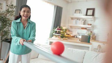 Büyükannenin elinde boru var ve göz, el koordinasyonunu geliştirmek ya da odaklanma ve konsantrasyonu arttırmak için top yuvarlama oyunu oynuyor. Yaşlı çift stresi azaltıyor. Sağlık hizmetleri. Myrmidon.