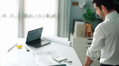 Ofiste dizüstü bilgisayar tasarımı kullanan mimar mühendisi, planlama ve ekipman dağınıklığı ile toplantı masasında otururken. Projede çalışan yetenekli inşaat mühendisi. Hizalama.