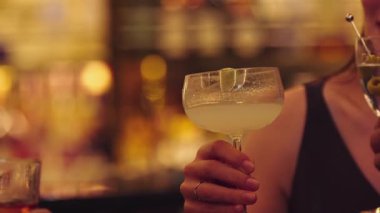 Yakın grup arkadaşları kokteyl martini, margarita ve paloma ile kadeh kaldırıyor. Lüks bir barda eski moda. Canlı bir gece kulübündeki özel bir partiyi kutlamak için canlı sohbetler. Vinosity.