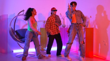 İspanyol hipster renkli kıyafetler giyer ve serbest stil müziğe el sallar. Profesyonel break dansçı neon ışıklarıyla ve modern stüdyo arkadaşlarıyla coşkuyla dans ediyor. Mutluluk.