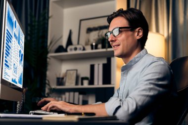 Akıllı iş adamı iş paragrafı dinamik pazarlama analizi planını analiz ediyor. Kağıt kağıtları ve bilgisayar monitörü raporlarını gece evdeki belge verileriyle karşılaştırmak için hazırlıyor. Bireysel.