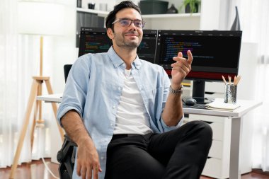 İki pc ekranda yazılım geliştirme kodlamasına karşı poz vermek için akıllı IT geliştiricisi görünümlü kamera, modern ofiste program güncellemesi sunuyor. Tahmin et..