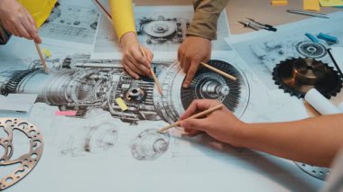 Modern çalışma alanındaki detaylı diyagramlar ve mekanik bileşenlerle çevrili, mühendislik tasarımı üzerine odaklanmış dinamik takım çalışması sahnesi uzmanları. SACTR