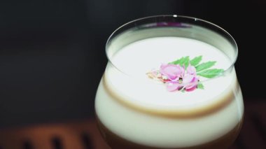 Tutkulu meyve suyu bardağında dönüşümlü, özel, ferahlatıcı, pembe çiçekle süslenmiş, lüks gece klübünde gece hayatı karışımı sergilenen bir içecek. Vinosity.