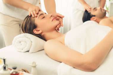 Kafkasyalı çift stres önleyici kafa masajının keyfini çıkarıyor ve lüks otellerde ya da otel spa salonlarında gündüz kaplıcalarında yüz güzelliği eğlencelerini şımartıyor. Sessiz.