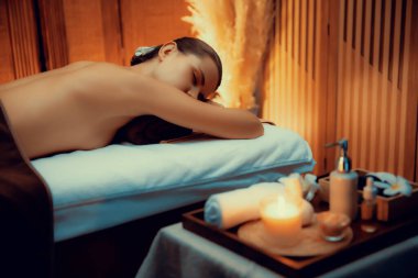 Aromaterapi masajı ambiyansı ya da spa salonu kompozisyon düzeneği bulanık kadınlara odaklı dekor mumları ve spa aksesuarları ile tatil köyü veya otel arka planında keyifli aroma spa masajı yapan. Sessiz.