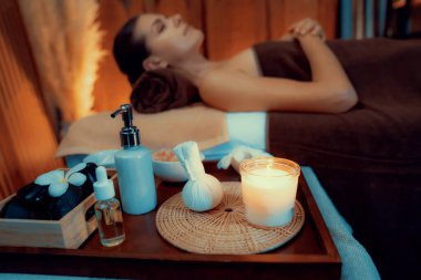 Aromaterapi masajı ambiyansı ya da spa salonu kompozisyon düzeneği bulanık kadınlara odaklı dekor mumları ve spa aksesuarları ile tatil köyü veya otel arka planında keyifli aroma spa masajı yapan. Sessiz.