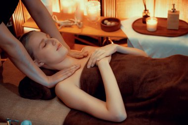 Beyaz kadın müşteri stres önleyici spa masajının keyfini çıkarıyor ve lüks otel ya da otelde sıcak mum ışığında güzellik teniyle eğleniyor. Sessiz.