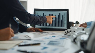 Profesyonel bir iş adamı modern bir ofiste, bilinçli kararlar ve stratejiler almak için bilgisayar ekranında gösterilen grafikleri ve grafikleri analiz eder.